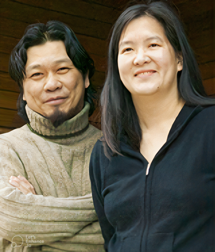 Peter Tan, in an olive knit turtleneck sweater and a goatee, stands with his arms crossed beside Christine Ho Ping Kong, wearing a zipped up navy blue hoodie.