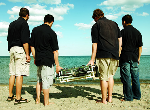 Photo of men on the beach with the aquabot