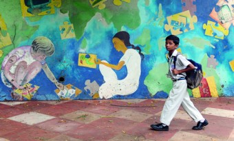 A child walking past a mural in Mumbai