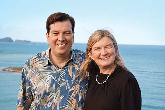 Steve Petranik, in a Hawaiian shirt, and Ann Auman, in a black blouse, with the ocean and a few small islands in the background