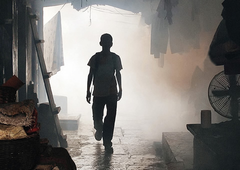 A silhouette of a figure emerging from a smoky room.