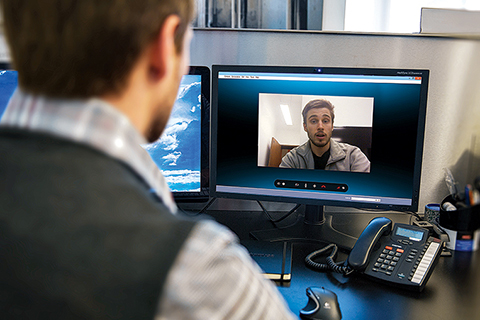 Photo of two men having a conversation via video conferencing software on a computer.