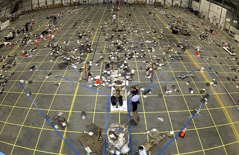 The Columbia Reconstruction Project Team place debris from the space shuttle Columbia on a grid as part of the investigation into the accident that caused the destruction of Columbia and the loss of its crew.