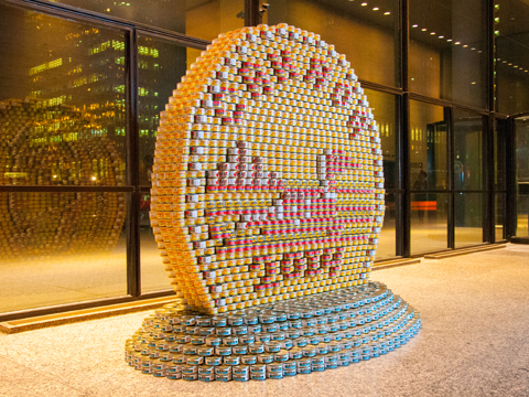 Photo of a giant loonie coin made from tuna cans.