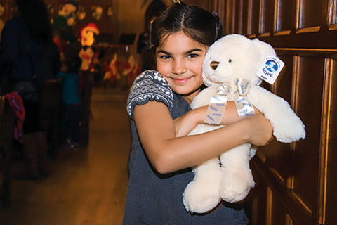 Photo of a young girl with a plush bear.