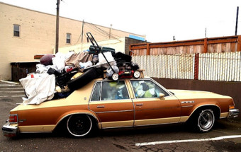 Photo of a pile of stuff on top of a car.
