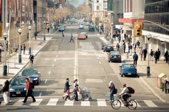 Photo of people crossing a busy city street.