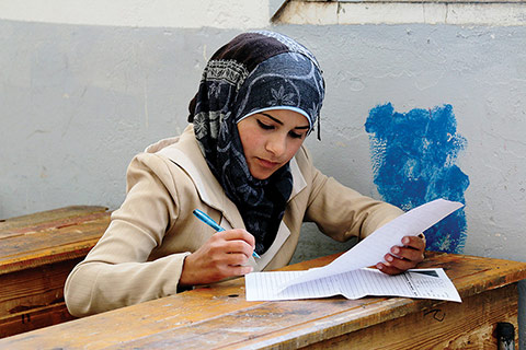 Photo of a young woman writing a test in school