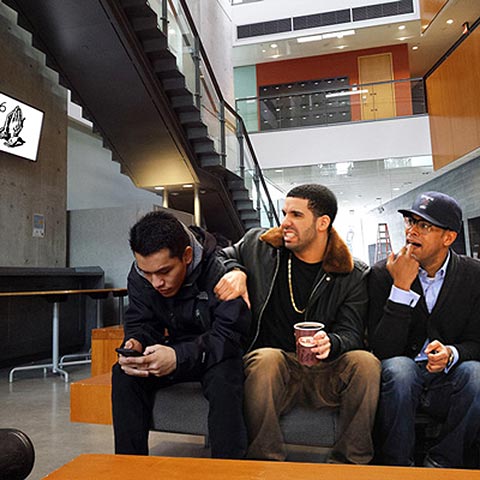 Photo of Drake sitting on a bench at UTSC with two friends