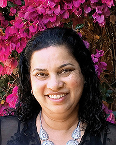 Headshot photo of Jeewika Ranaweera with pink flowers in the background