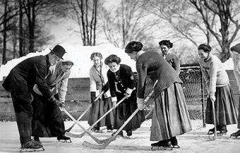 Photo of the Varsity women's hockey team playing a match on an outdoor rink (winter 1910)