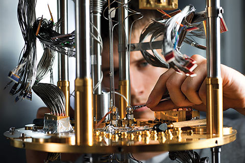 Close up shot of researcher turning a screw on a quantum computer.