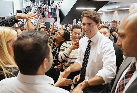 Photo of Justin Trudeau greeted by a large crowd of students inside Rotman.