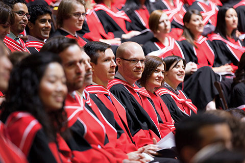 Close up photo of PhD graduates in convocation robes seated during convocation.