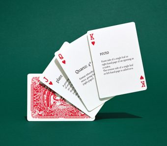 Photo of four cards, the top three facing up showing the Jack, Queen and King of hearts with definitions for "plate," "quarto," and "recto" in the centre of the respective cards.