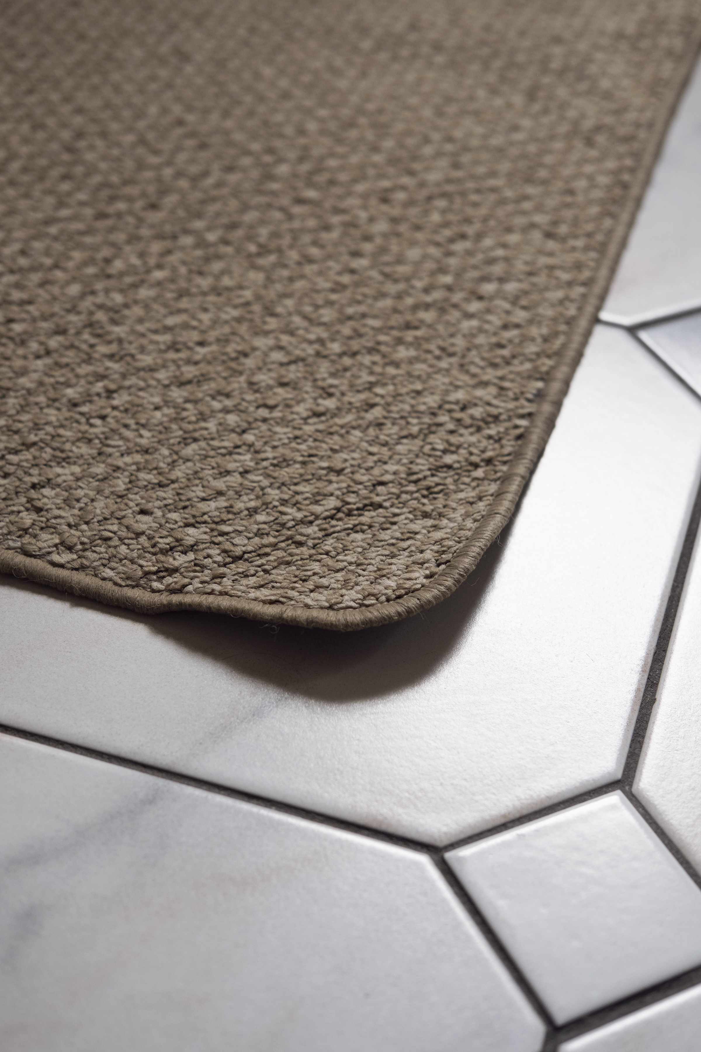 The edge of a carpet over a tile floor