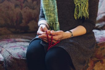 Laura Alary holds a mala as she thinks about the specific things she's grateful for in her life