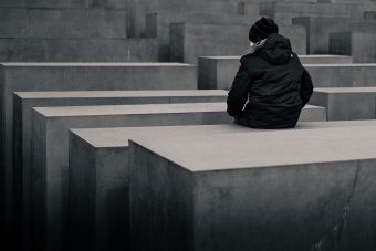 A person sits on the Holocaust Memorial concrete blocks in Berlin, Germany