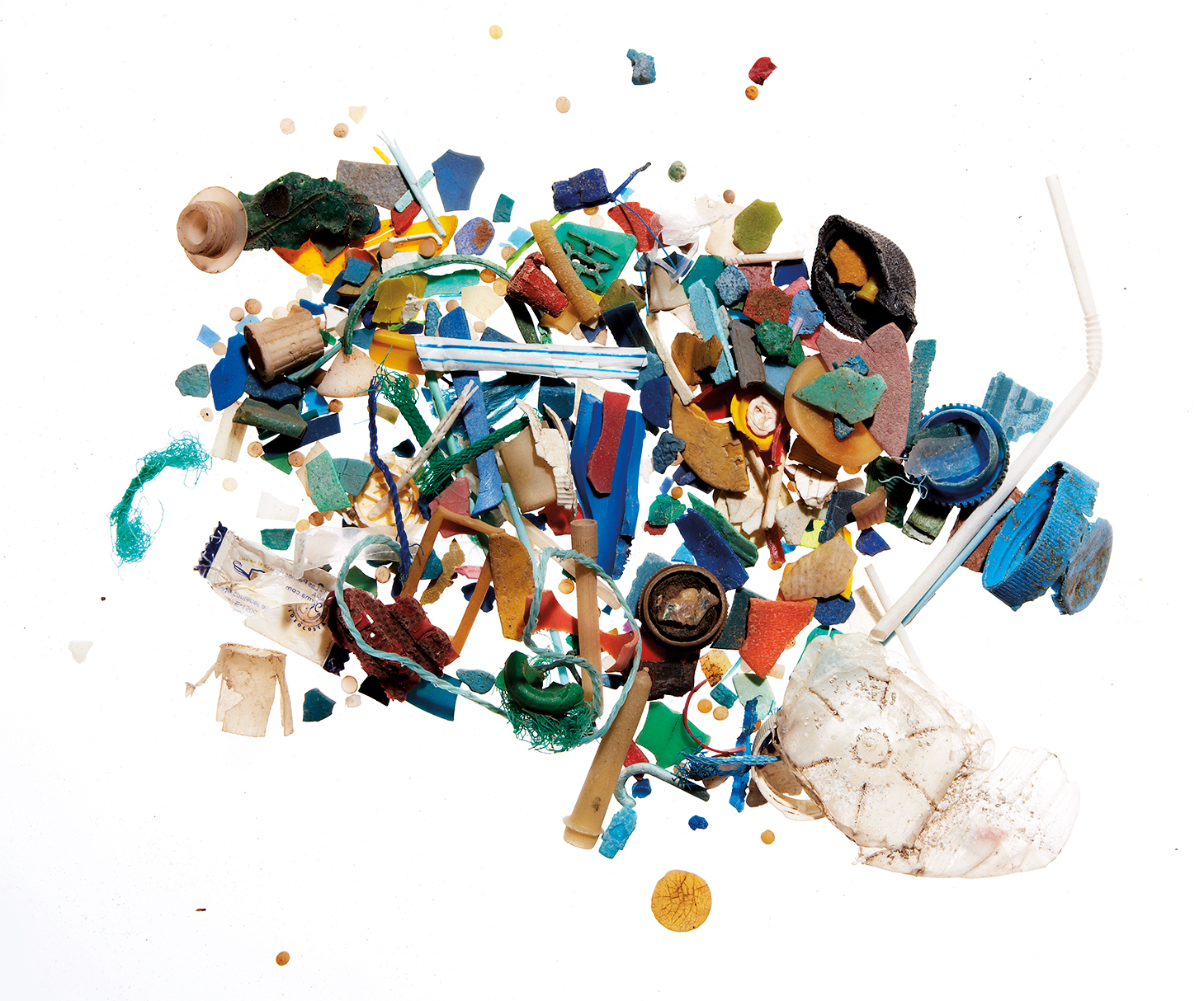 A pile of many different teeny tiny pieces of plastic in a variety of colours, including pieces of straws, plastic water bottle lids.