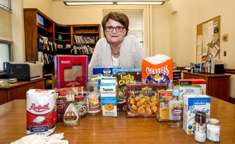 Prof. Mary L'Abbé standing behind a table of different packaged foods