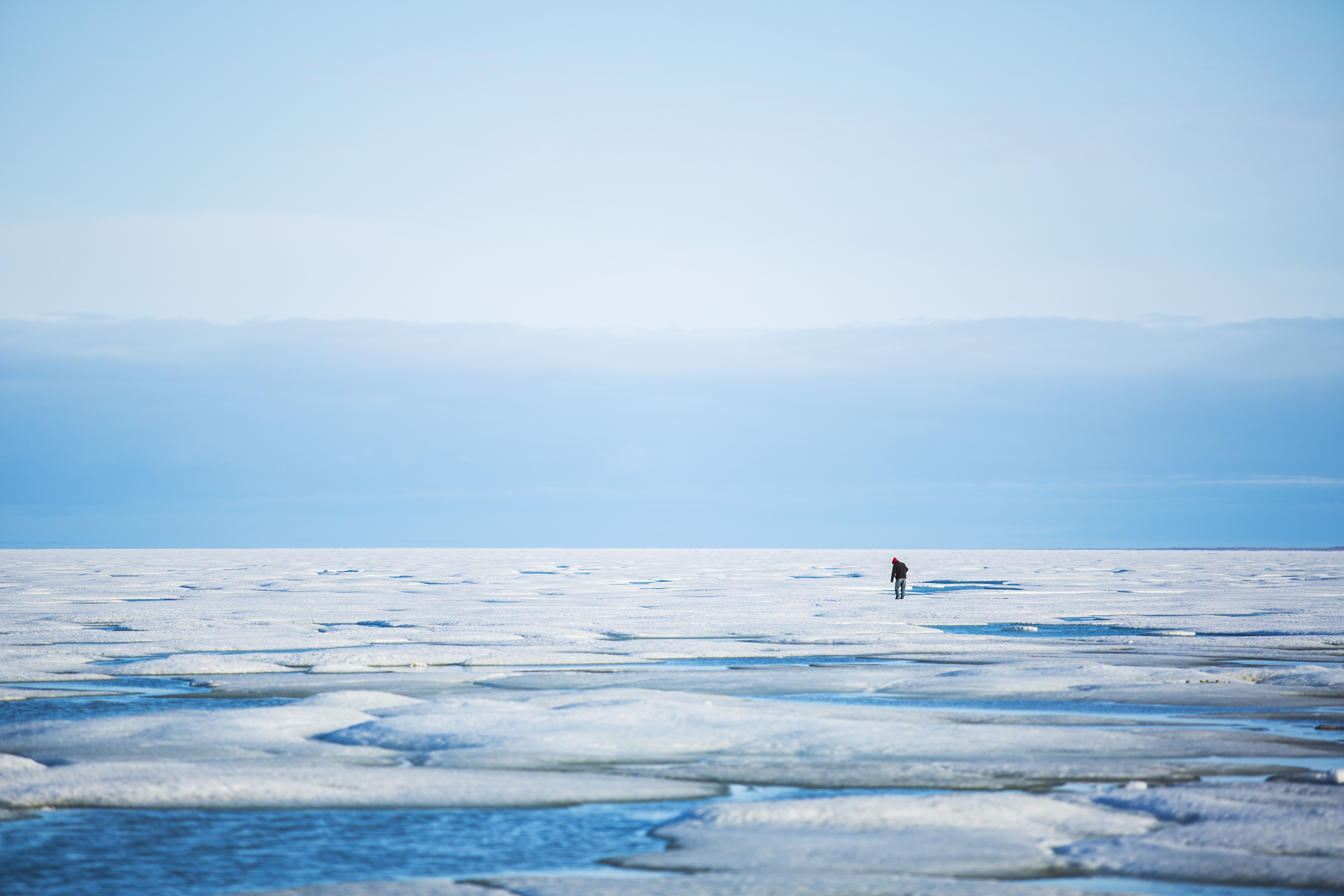 A man walks across the ice in Gjoa Haven.