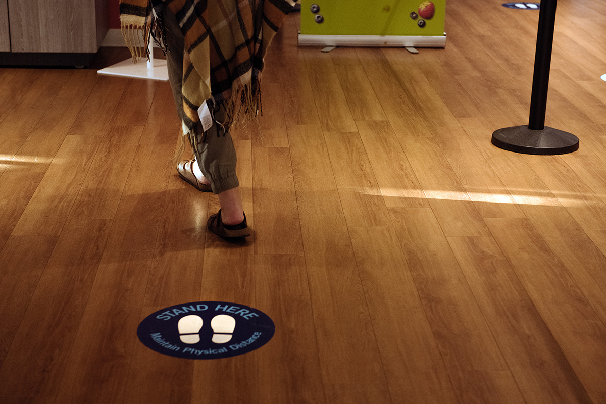 Circular decal on the floor, showing a pair of footsteps and the words 