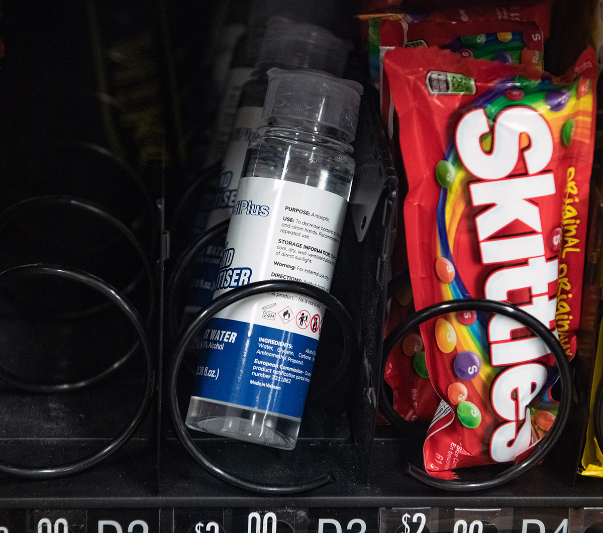 Bottles of hand sanitizer and packages of Skittles inside a vending machine