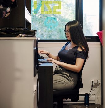 Shirley Liu sitting at her desk, typing on her keyboard
