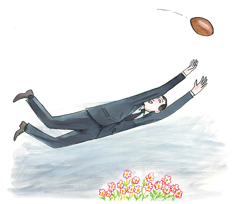 Man in a business suit midair trying to catch a football