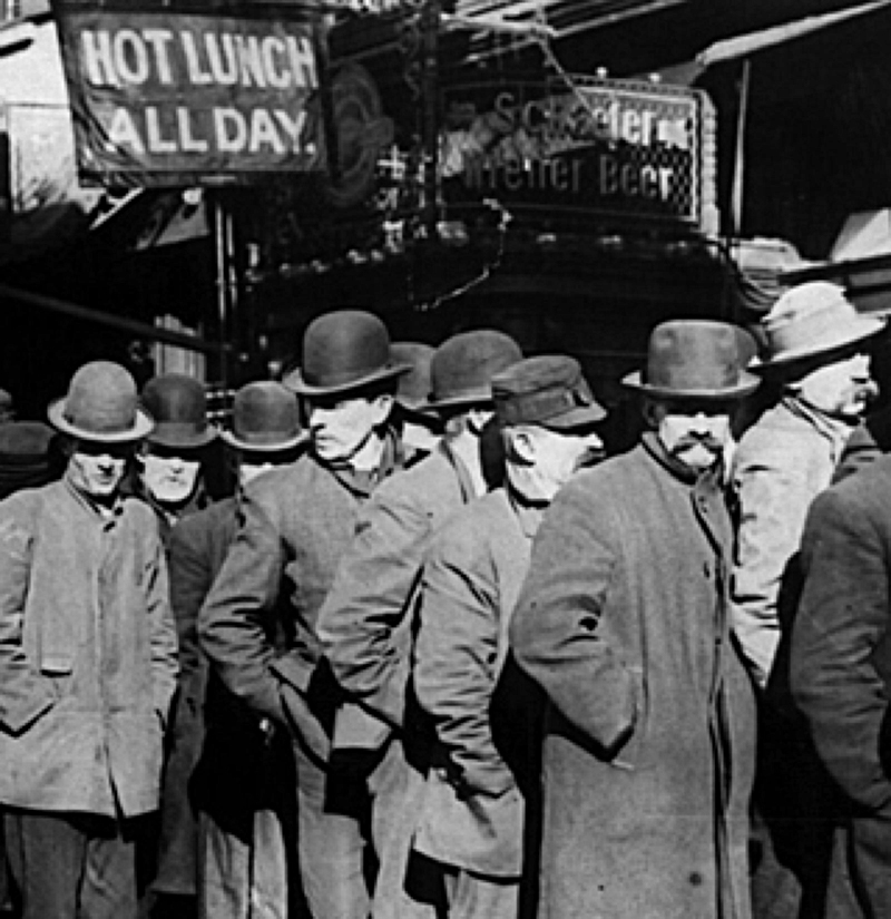 Black and white photo of men in hats and trench coats standing in line