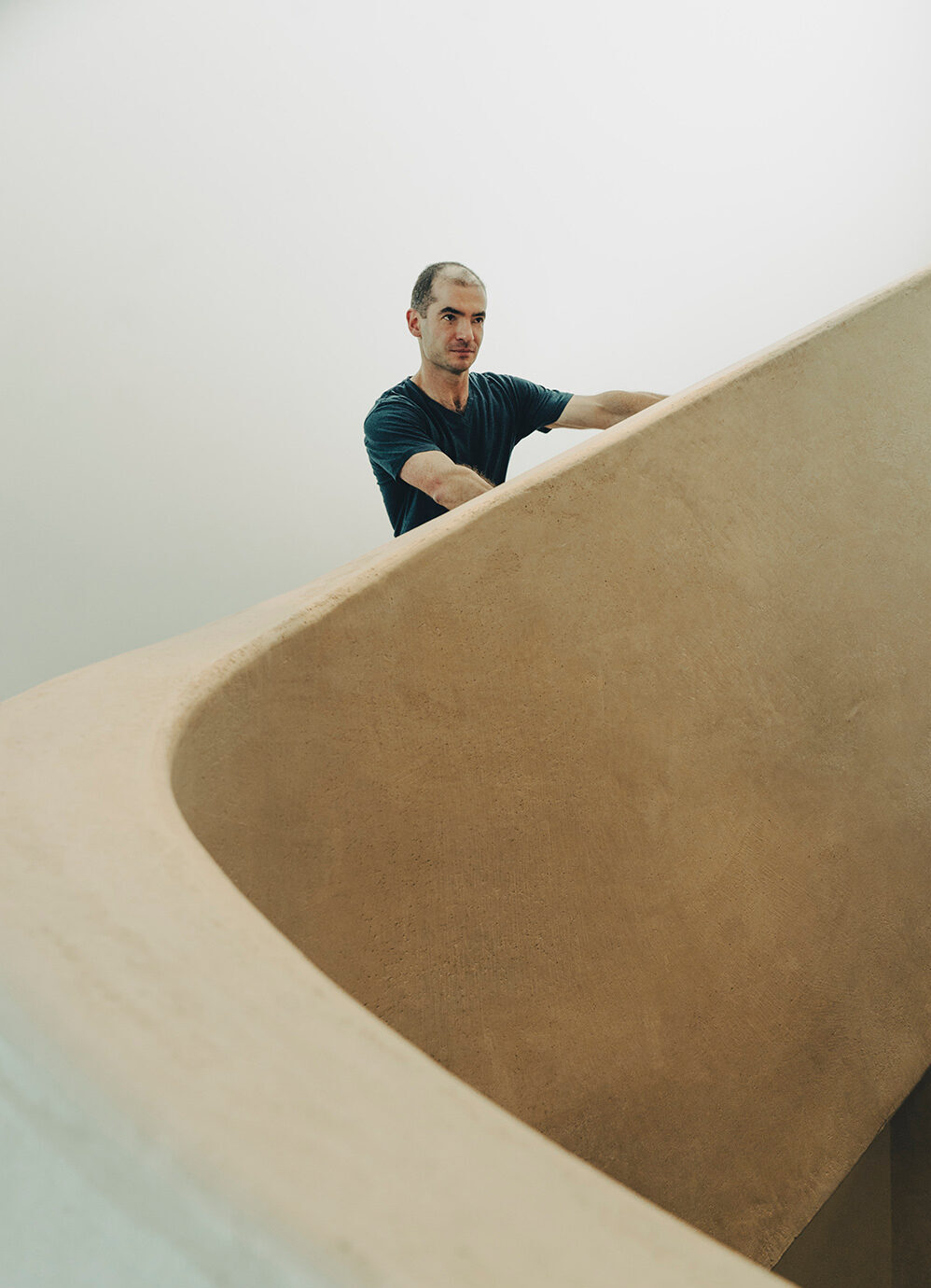 Ilya Sutskever standing on a staircase with beige-coloured curved sides