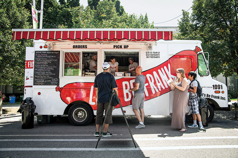 People ordering food from the Let's Be Frank food truck