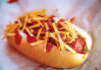 A hot dog dressed with ketchup and fried onions