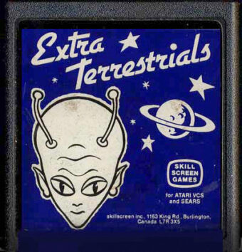 Front of the "Extra-Terrestrials" video game cartridge, depicting stars, a planet, and the head of an alien