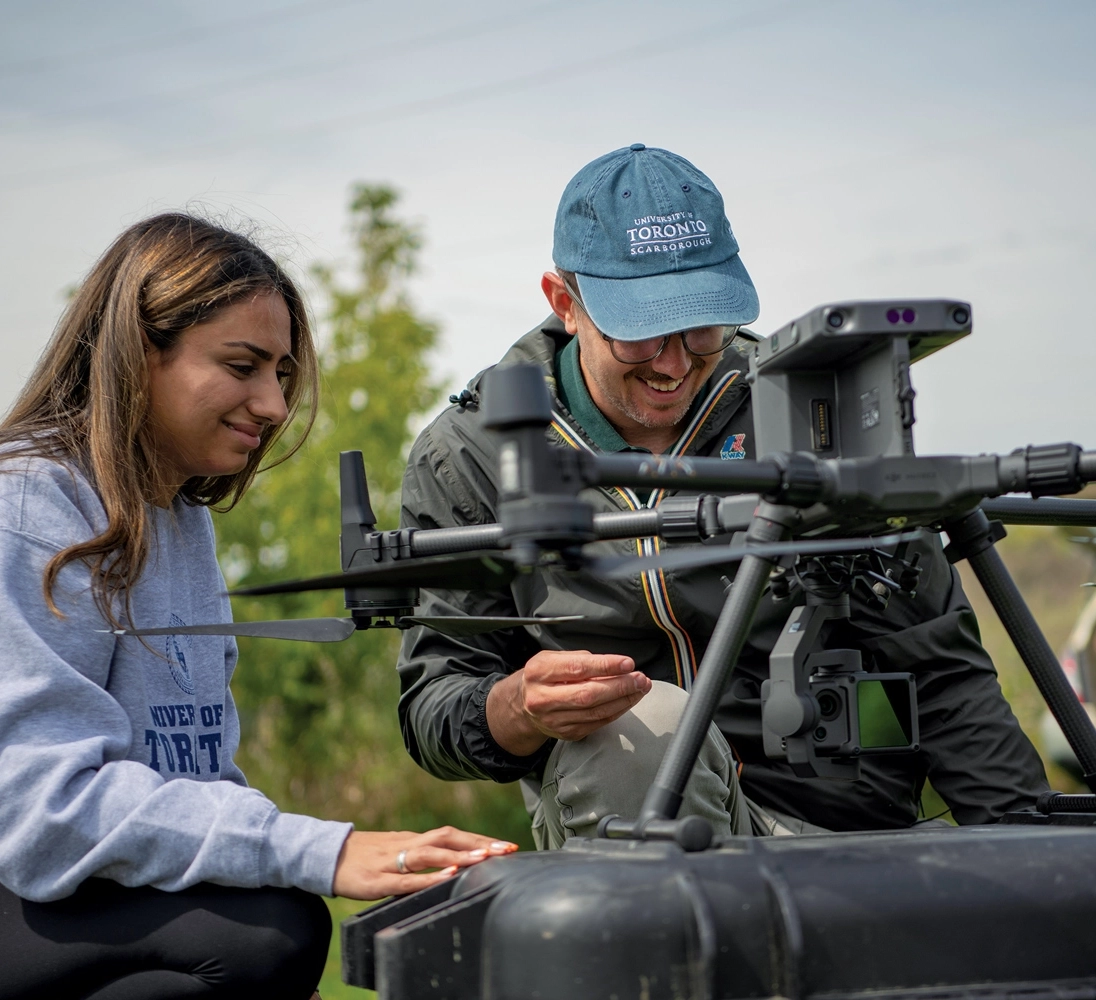 Two researchers are checking an aerial drone on the ground