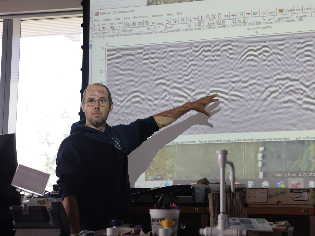 Tom Meulendyk is pointing to a section of wave data projected onto a screen