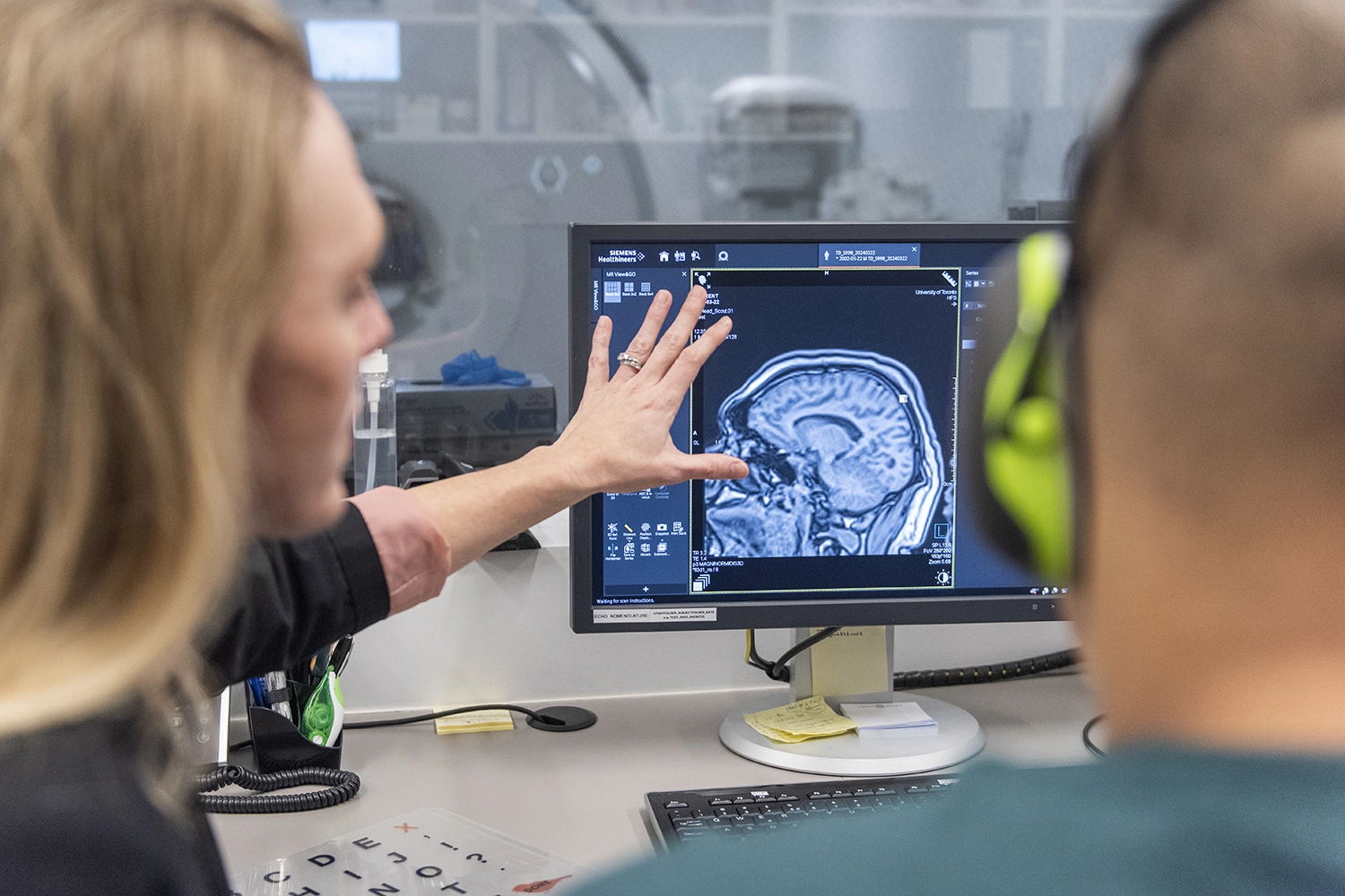 Morgan Barense (left) and Isaiah Grewal are looking at a computer monitor displaying the MRI scan of Grewal's brain.