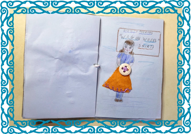 Open handmade book showing a drawing of a girl with a belt made of a button sewn into the drawing