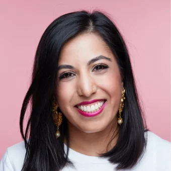 Studio headshot of Ishani Nath against a pink background