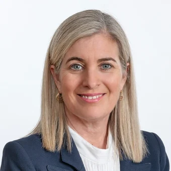 Studio headshot of U of T President Melanie Woodin in a white blouse and navy blue blazer