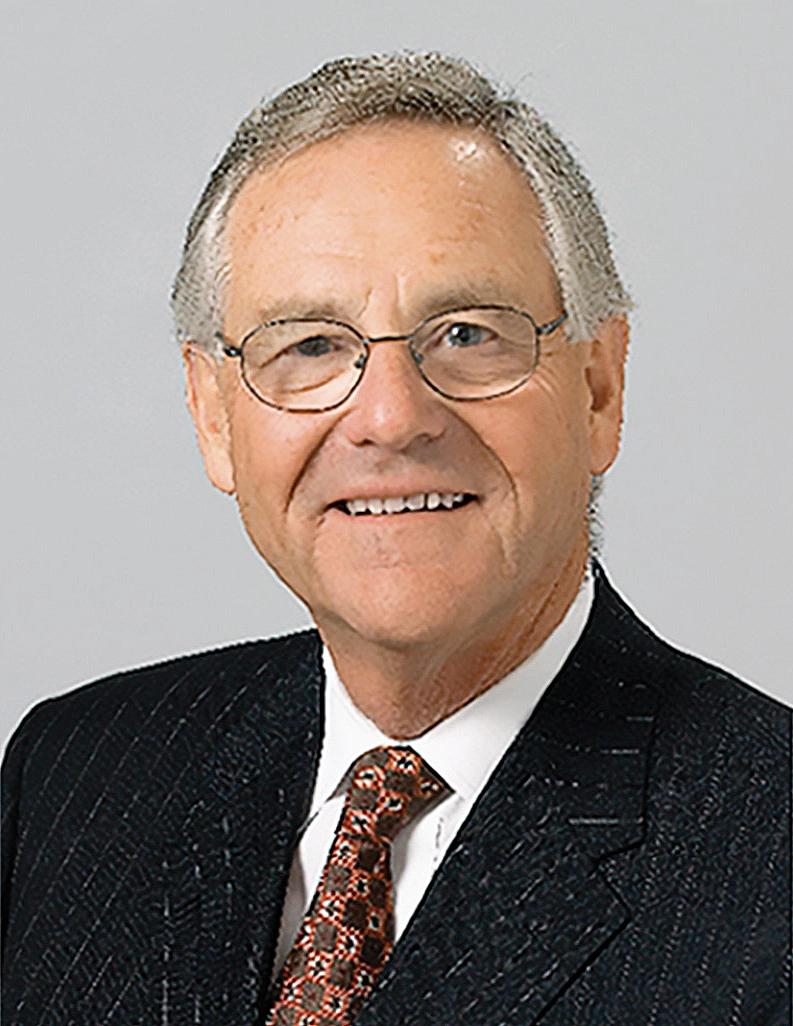 Studio headshot of Robert Gillespie in a dark striped blazer and tie